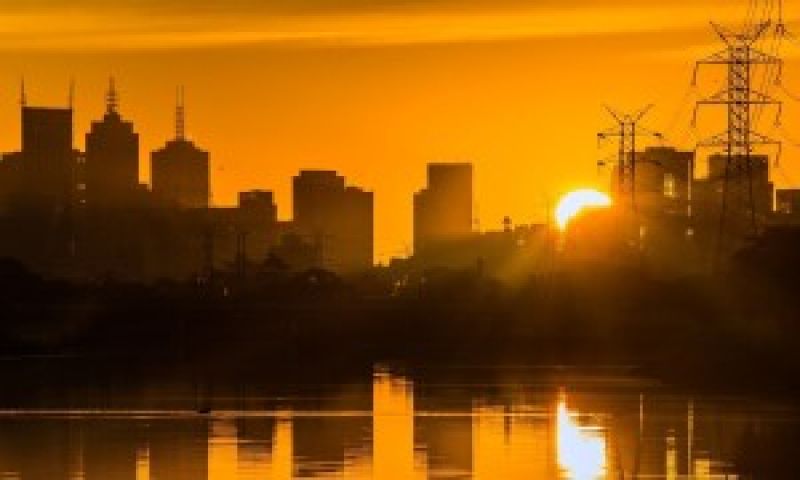 Image of city buildings with Yarra River in front at sunset